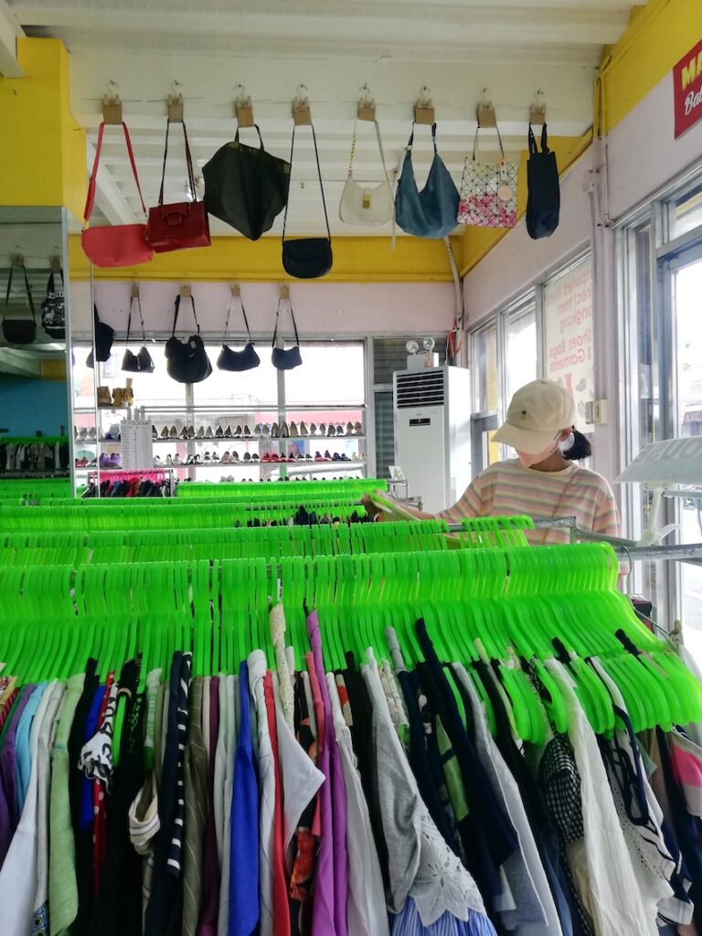 A familiar view for ukay-ukay shoppers: Racks of secondhand clothes hung on neon green hangers.